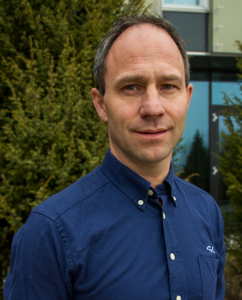 Portrettbilde av Bjørn Ove Bergh tatt utendørs foran hekk.