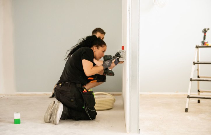 Lise Renate Røtting borrer i veggen. Foto: GK Gruppen